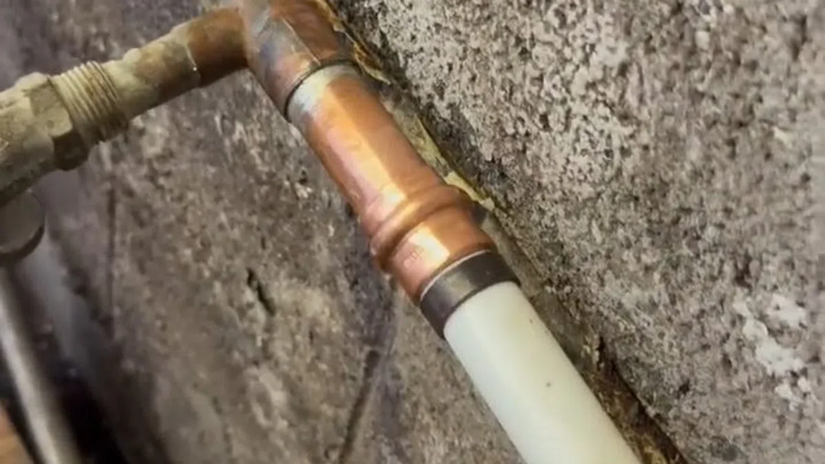 Exposed water line connection being repaired near an outdoor or utility access point for Plumbing Services in Sun City,