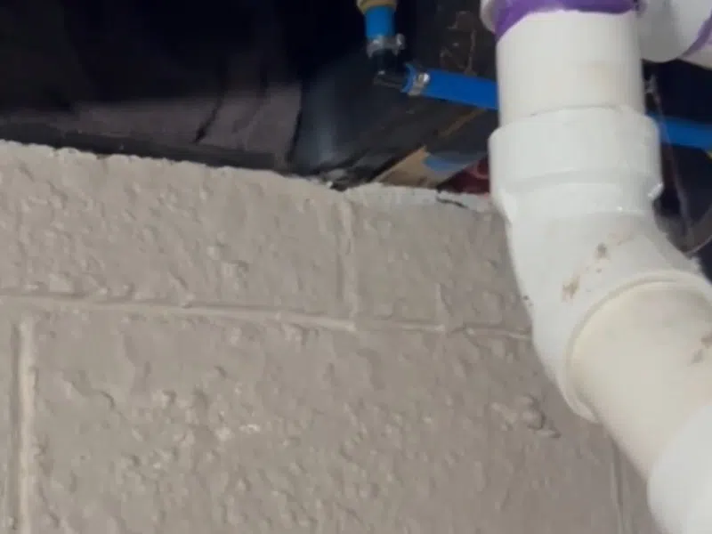 Exposed water line connection being repaired near an outdoor or utility access point for Sewer Line Repair in Goodyear