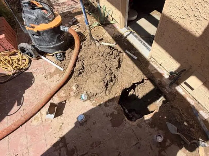 Opened slab area and leak detection equipment used to locate a hidden pipe leak for Slab Leak Detection & Repair in Goodyear showing opened slab area leak detection equipment used locate hidden pipe repair closeup
